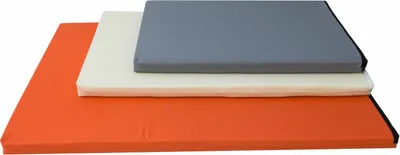 Three stacked dog mats of different colors and sizes.