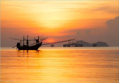 Produktbild von Wallario Fototapete Vliestapete, seidenmatte Oberfläche, einfache Verarbeitung, Größe 300 x 210 cm, Motiv Thailändisches Fischerboot vor Sonnenuntergang