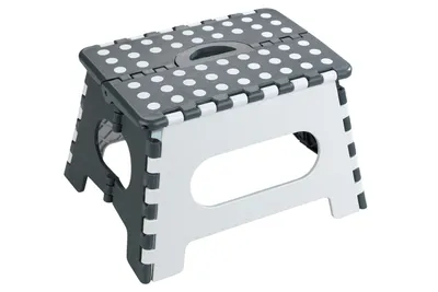 A gray and white folding step stool with a polka dot pattern on the top surface.