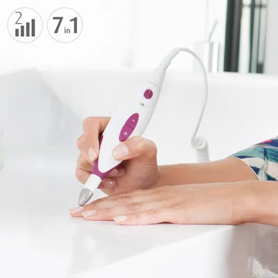 A person's hands are shown using an electric manicure and pedicure set.