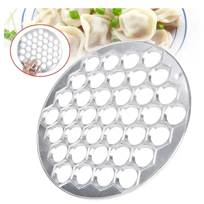 A dumpling maker mold is shown in the foreground, with a plate of cooked dumplings in the background.