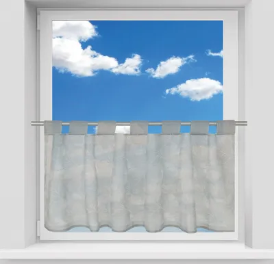 A sheer gray bistro curtain hangs in a window with a blue sky and clouds visible through it.