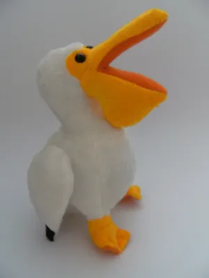 A plush toy pelican sitting on a white surface.