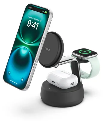 A white background with a charging station holding an iPhone, Apple Watch, and AirPods.