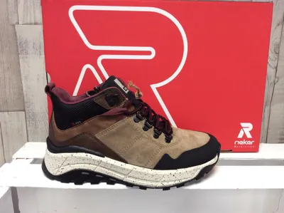 A shoe is displayed in front of a red box with a large white 'R' logo.