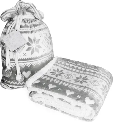 A folded blanket with a Christmas pattern and a matching drawstring bag.