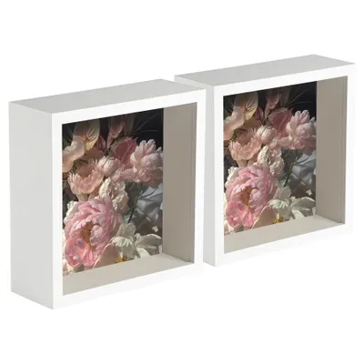 Two white deep box picture frames, each containing a floral arrangement of pink and white flowers.