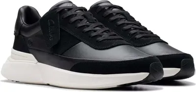 A pair of black Clarks sneakers with white soles, shown from a slightly elevated side angle against a white background.