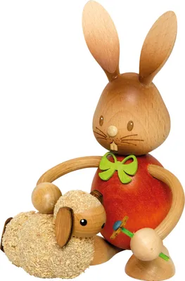 A wooden Easter decoration of a rabbit holding a lamb.