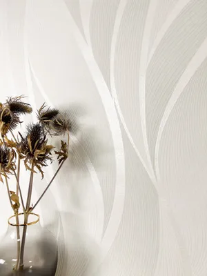 A close-up of wallpaper with a wavy pattern and a vase of dried flowers.