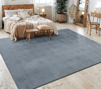 A bedroom with a bed, rug, and furniture.