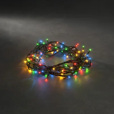 A coiled string of multicolored LED lights on a dark, textured surface.