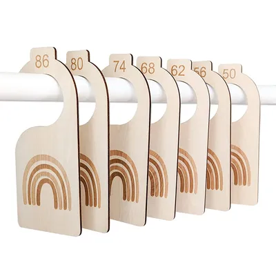 A set of wooden baby clothing size dividers with rainbow designs, hanging on a rod.