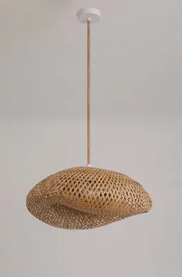 A pendant light fixture made of woven bamboo hangs from a white ceiling mount.