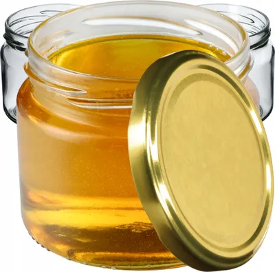 Three glass jars filled with honey, one with a gold lid slightly ajar.