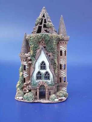Eine verfallene Burg. Der Turm ist mit Efeu bewachsen und zeigt deutliche Zeichen von Verwitterung.