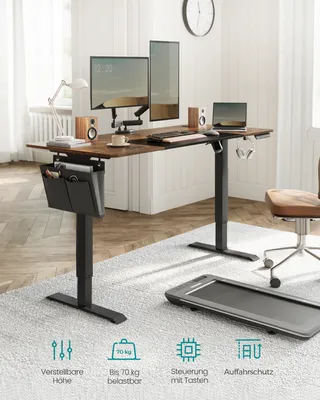 A modern home office setup featuring a standing desk with dual monitors, a laptop, and accessories, with a small treadmill in the foreground.