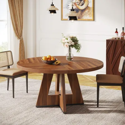A dining room scene with a round wooden table, chairs, and decorative elements.