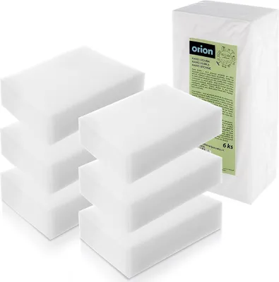Several white cleaning sponges are stacked in front of a package of sponges.