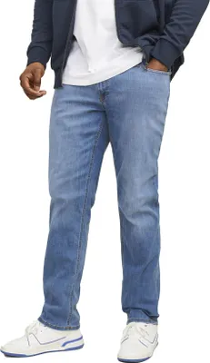 A person wearing blue jeans and white sneakers.