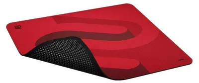 A red mousepad with a black textured underside is shown from a diagonal angle.