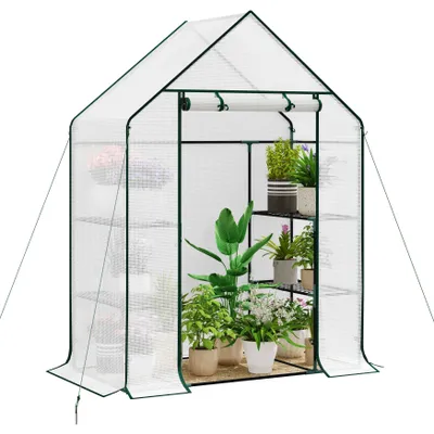 A white greenhouse with shelves filled with potted plants.