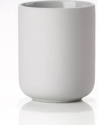 A studio shot of a soft grey ceramic toothbrush holder on a white background.