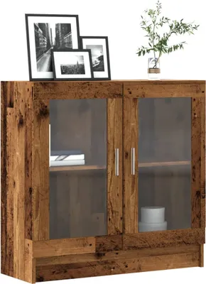 A wooden cabinet with glass doors, decorated with framed pictures and a plant.