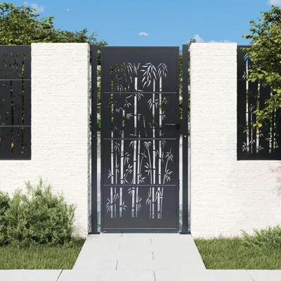 A garden gate with a bamboo design, set against a white brick wall and green foliage.
