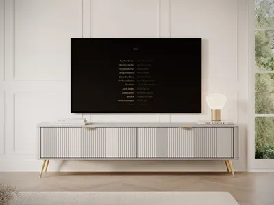 A modern TV stand with a TV displaying credits in a living room setting.