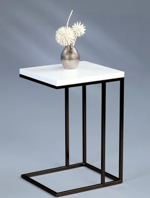 A white side table with a chrome frame and a vase with decorative flowers on top, set against a plain gray background.