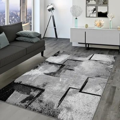 A modern living room with a sofa, rug, and side table.
