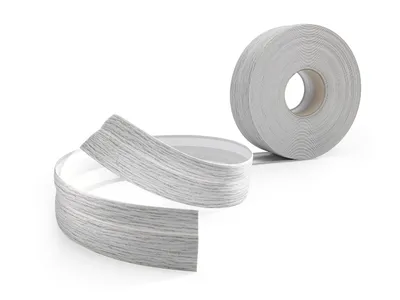 A roll of flexible PVC baseboard trim with a wood-like texture is shown, with a portion unrolled and curved.