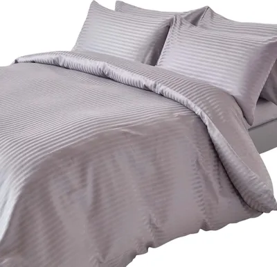 A close-up view of a gray striped duvet cover and pillowcases on a bed.