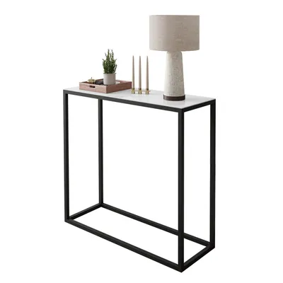 A console table with a lamp, candles, and a small plant on top, set against a white background.