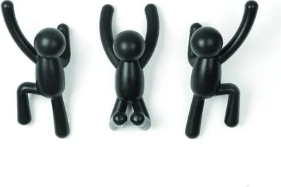 Three black wall hooks shaped like stick figures climbing a wall.