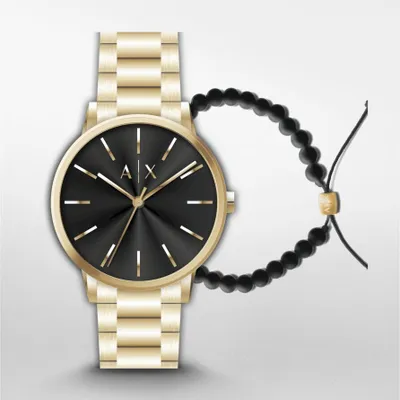 A gold watch with a black face and a black beaded bracelet.