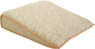 A wedge-shaped cushion with a textured, cream-colored cover and tan trim, shown against a white background.