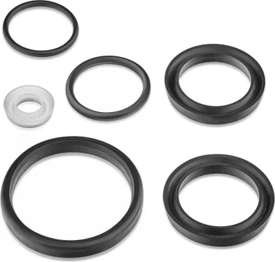 A collection of black and one white rubber rings or gaskets laid out on a white background.