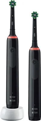 Two black electric toothbrushes are shown on a white background. One is standing in a white charging base.