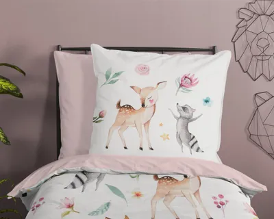 A bed with bedding featuring a woodland animal print.