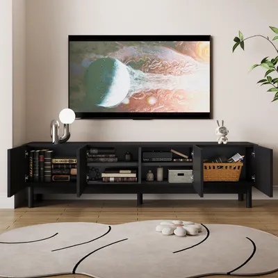 A black TV stand with open doors, displaying books and storage items, in a living room setting with a TV on the wall and a rug on the floor.