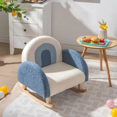 A child's rocking chair with a rainbow design is placed in a room with a white dresser and a small round table.