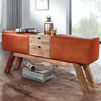 A leather bench with wooden drawers, placed on a rug in a room with a window.