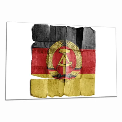 Produktbild von Wallario Herdabdeckplatte aus Glas, Größe 90 x 52 cm 1-teilig, Motiv DDR Flagge auf altem Papier - schwarz rot gold