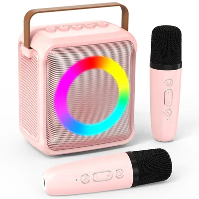 A pink karaoke machine with two pink microphones and a colorful LED light ring.