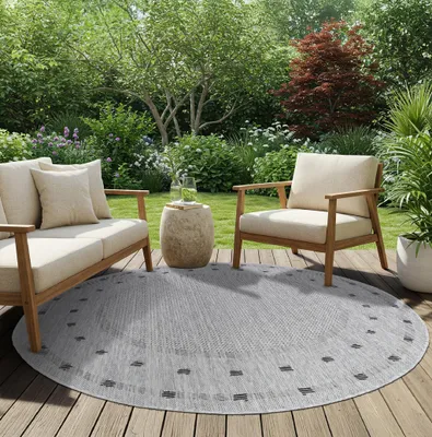 An outdoor patio scene with furniture and a rug.