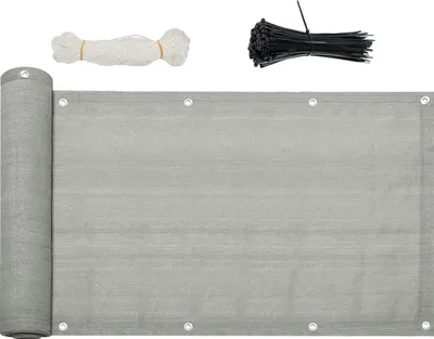 A rolled-up gray balcony privacy screen with grommets, along with a bundle of white rope and a bundle of black zip ties, laid out on a white background.