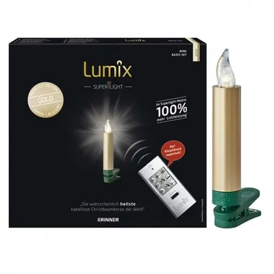 The image shows the packaging of Krinner LED Christbaumkerzen Lumix Superlight Mini Goldfarben Basis, along with a single LED candle and a remote control.