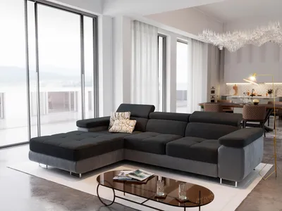 A modern living room with a large sectional sofa, coffee table, and dining area visible in the background.